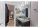 Bathroom with granite countertop, dark vanity, and view of home theater at 9076 Hazard St, Davenport, FL 33896