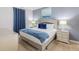 Bedroom with king-size bed, blue blanket, and neutral decor at 9076 Hazard St, Davenport, FL 33896