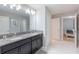 Bathroom with double sinks, granite countertop, and view of bedroom at 9076 Hazard St, Davenport, FL 33896