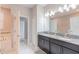 Double vanity bathroom with granite countertop and dark cabinets at 9076 Hazard St, Davenport, FL 33896
