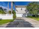 Two-car garage with driveway and a white fence at 114 Eastpark Dr, Celebration, FL 34747