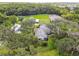 Aerial view of a house nestled in lush greenery, with a barn and pasture visible at 4600 Nebraska Ave, Sanford, FL 32771