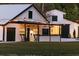 White barn with black accents, string lights, rocking chairs, and a covered patio at 4600 Nebraska Ave, Sanford, FL 32771