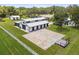 Aerial view of a modern barn with ample parking and a large sand arena at 4600 Nebraska Ave, Sanford, FL 32771