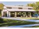 White barn with black accents, multiple stalls, and a covered patio area at 4600 Nebraska Ave, Sanford, FL 32771