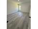 Large bedroom with grey wood-look floors and a window at 14954 Sw 38Th Cir, Ocala, FL 34473