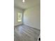 Bright bedroom with grey wood-look floors and a window at 14954 Sw 38Th Cir, Ocala, FL 34473