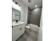 Clean bathroom with white vanity, grey tile, and bathtub at 14954 Sw 38Th Cir, Ocala, FL 34473