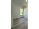 Spacious bedroom with grey wood-look floors and a window at 14954 Sw 38Th Cir, Ocala, FL 34473