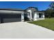 Modern home with gray garage door and green lawn at 14954 Sw 38Th Cir, Ocala, FL 34473