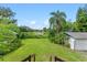 Large backyard with lush lawn, lake view, and shed at 1803 E Kaley Ave, Orlando, FL 32806