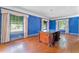 Living room with hardwood floors, blue walls, and a large antique table at 1803 E Kaley Ave, Orlando, FL 32806