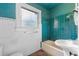 Bathroom with teal tile, pedestal sink, and vintage tub at 1803 E Kaley Ave, Orlando, FL 32806
