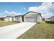 New gray house with light blue shutters and a two-car garage at 1748 Forest Run Ln, Auburndale, FL 33823