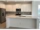 Modern kitchen with white cabinets, stainless steel appliances and an island at 6821 Serpent Hawk Lane St, Howey In The Hills, FL 34737