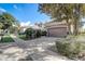 Two-car garage with a brown door and landscaped yard at 8503 Saint Marino Blvd, Orlando, FL 32836