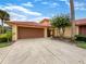 Front view of a tan house with a brown garage door at 4934 Samoa Cir # 7, Orlando, FL 32808