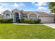 One story home with gray siding, two car garage and lush lawn at 12337 Greco Dr, Orlando, FL 32824