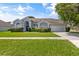 One story home with gray siding, two car garage and lush lawn at 12337 Greco Dr, Orlando, FL 32824