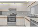 Stainless steel appliances and light wood cabinets in this galley kitchen at 2384 Sun Valley Cir, Winter Park, FL 32792
