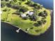 Aerial view of a waterfront property with a large house, expansive lawn, and private dock at 16600 Cleveland Ln, Umatilla, FL 32784