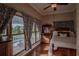 Bedroom with antique bed and large windows overlooking the backyard at 16600 Cleveland Ln, Umatilla, FL 32784