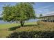 Landscaped yard with lake view and mature trees at 16600 Cleveland Ln, Umatilla, FL 32784