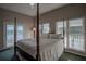 Main bedroom with a four-poster bed and access to a private balcony at 16600 Cleveland Ln, Umatilla, FL 32784