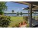 Peaceful water views and lush landscaping from the porch at 16600 Cleveland Ln, Umatilla, FL 32784