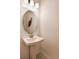 Modern bathroom with pedestal sink and round mirror at 1227 Teal Creek Dr, Saint Cloud, FL 34771