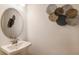 Stylish powder room with pedestal sink and decorative wall art at 1227 Teal Creek Dr, Saint Cloud, FL 34771