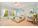 Bright bedroom with queen bed, light blue walls, and large windows at 1650 Lakehurst Ave, Winter Park, FL 32789