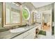 Elegant bathroom with double sinks, a large mirror, and a view of the bedroom at 1650 Lakehurst Ave, Winter Park, FL 32789