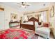 Spacious main bedroom with a large bed, red rug, and chaise lounge at 1650 Lakehurst Ave, Winter Park, FL 32789
