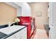 Laundry room with red appliances and white cabinets at 1650 Lakehurst Ave, Winter Park, FL 32789