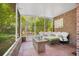 Relaxing screened porch with brick flooring, wicker furniture, and fire pit at 1650 Lakehurst Ave, Winter Park, FL 32789