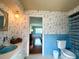 Retro bathroom with blue tile, floral wallpaper, and a vintage vanity at 349 Bodie St, Longwood, FL 32750