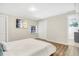 Main bedroom with a simple white bed and access to bathroom at 1500 N Clearview Ave, Deland, FL 32724