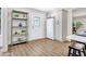 Kitchen with white cabinets, white fridge, and grey shelving unit at 1500 N Clearview Ave, Deland, FL 32724