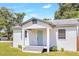 Charming bungalow with a light-grey exterior, teal door and grey steps at 1500 N Clearview Ave, Deland, FL 32724