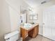 Bathroom with wood vanity, sink, and toilet at 744 La Mirage St, Davenport, FL 33897
