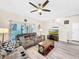 Living room with gray sectional sofa, TV, and wood floors at 744 La Mirage St, Davenport, FL 33897