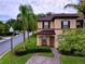 Two-story house with brown roof and landscaping at 744 La Mirage St, Davenport, FL 33897