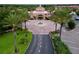 Community entrance with circular drive and manicured landscaping at 744 La Mirage St, Davenport, FL 33897