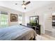 King bed, dresser, and ceiling fan in bright bedroom with kitchen view at 744 La Mirage St, Davenport, FL 33897