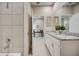 Double vanity bathroom with granite countertops and a view of the hallway at 12922 Trovita Dr, Grand Island, FL 32735