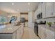 Modern kitchen with white cabinets, granite countertops and stainless steel appliances at 12922 Trovita Dr, Grand Island, FL 32735