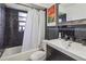 Clean bathroom with dark tile, white vanity, and a bathtub shower combo at 501 N Normandale Ave, Orlando, FL 32835