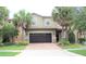 Two-story house with dark brown garage door and palm trees at 9054 Rhodes St, Kissimmee, FL 34747