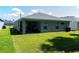 Rear view of a single-story house with covered patio and grassy yard at 3882 Willow Ridge Dr, Lakeland, FL 33810
